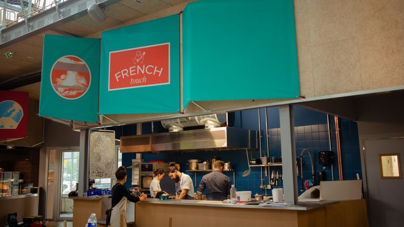 Installé dans les anciennes halles Alstom, l’espace de restauration abrite 11 kiosques avec une offre culinaire variée, un bar et 450 places assises. © Célia Le Goaziou
