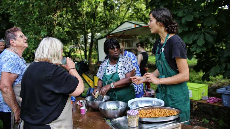 Une dizaine de bénévoles participent à la préparation du repas collectif ce mercredi 17 juillet au parc de la Roche à Malakoff. © Romain Boulanger